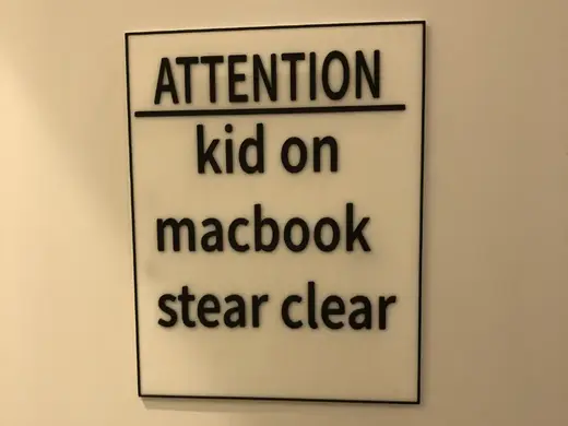 kid on MacBook sign with ams